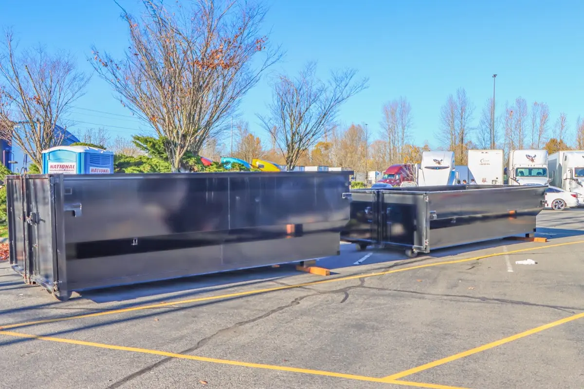 Professional dumpster rental service with roll-off container on residential driveway in Thomson